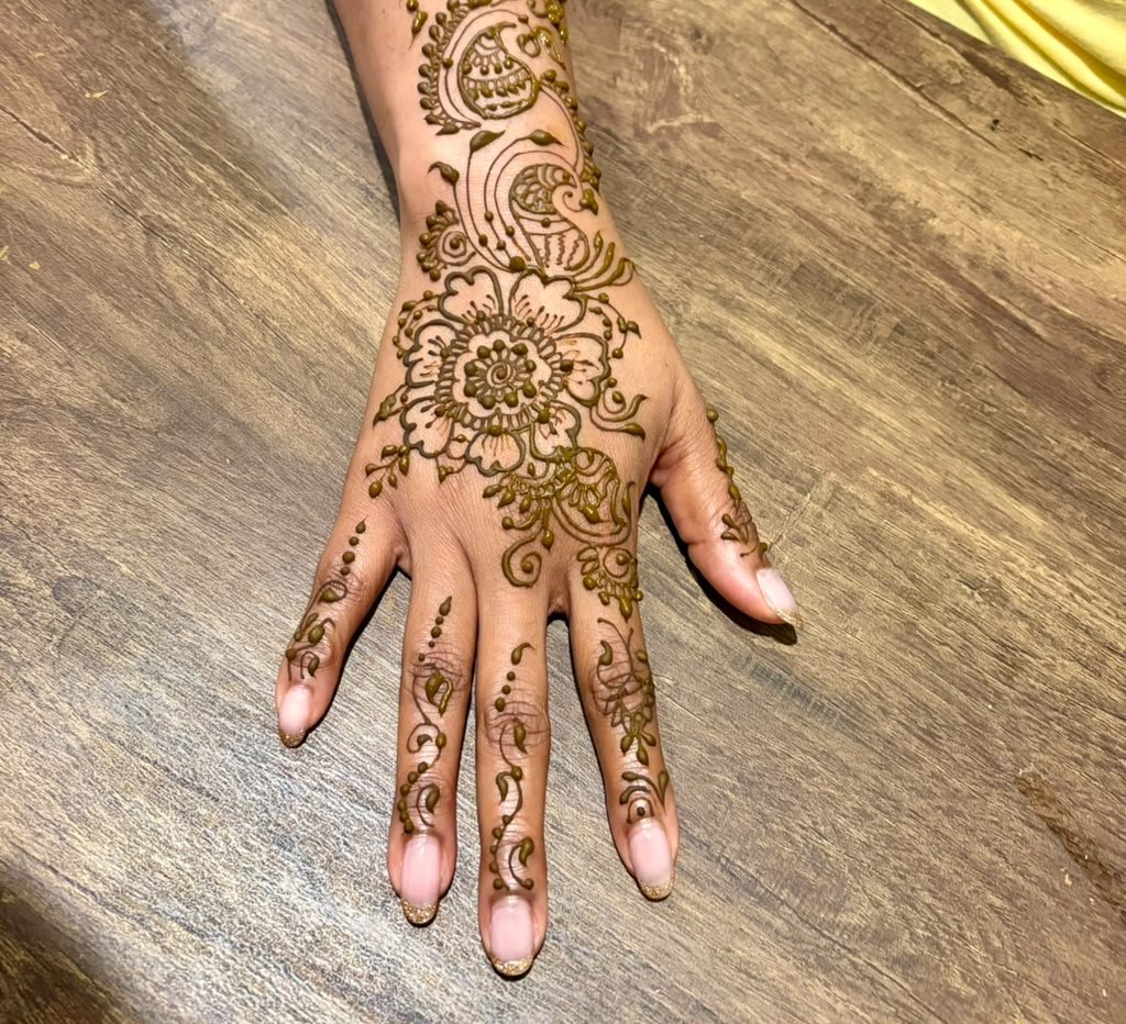 Delicate flower and trailing vine henna on the back of a hand